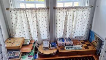 A room with a window, curtains, and a Monopoly board game.