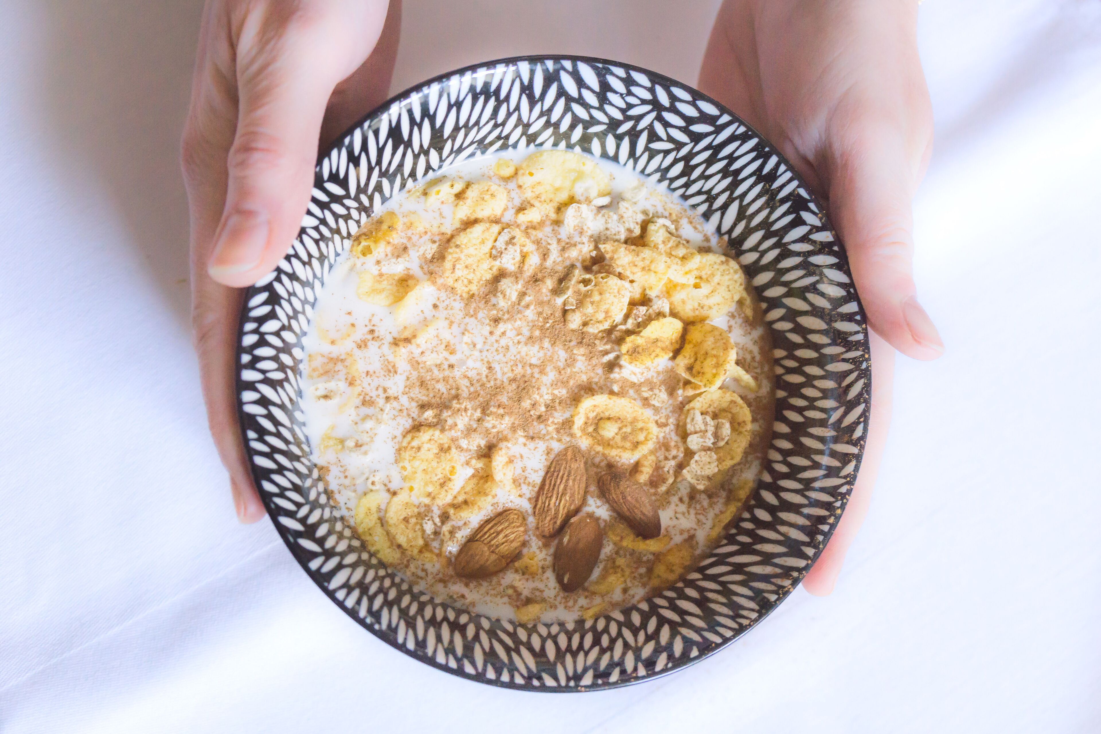A bowl of oatmeal with almonds and cinnamon.