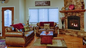 A living room with leather sofas, a fireplace, and a sign that reads "MONTANA".