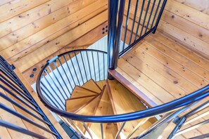 A spiral staircase with wooden walls and metal railings.