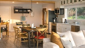 Una cucina accogliente con zona pranzo, arredi in legno e un'ampia finestra che offre vista sull'esterno.