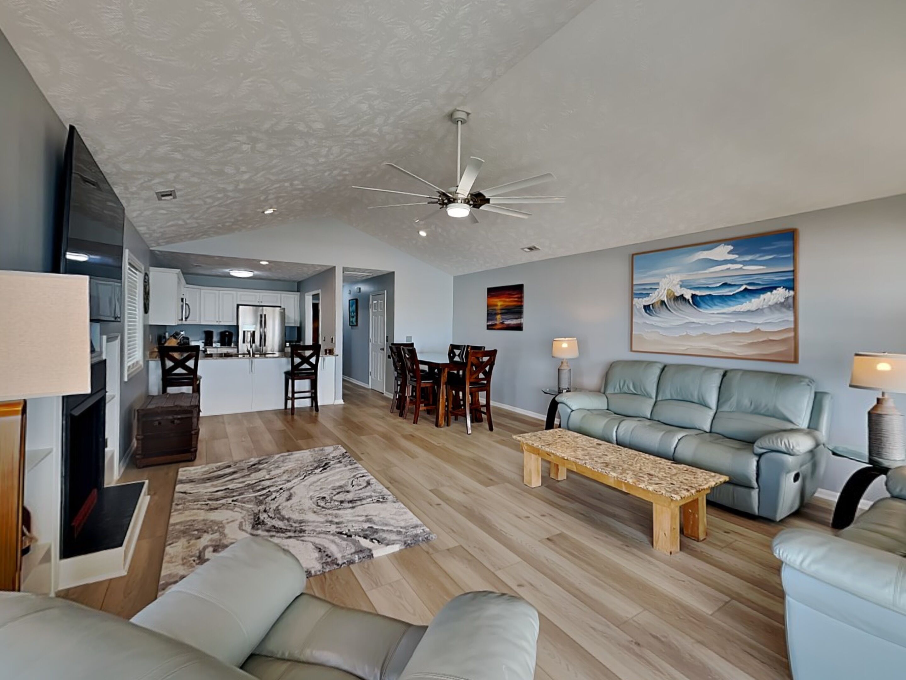 A spacious living room with a sofa, a coffee table, and a dining area with chairs and a table.