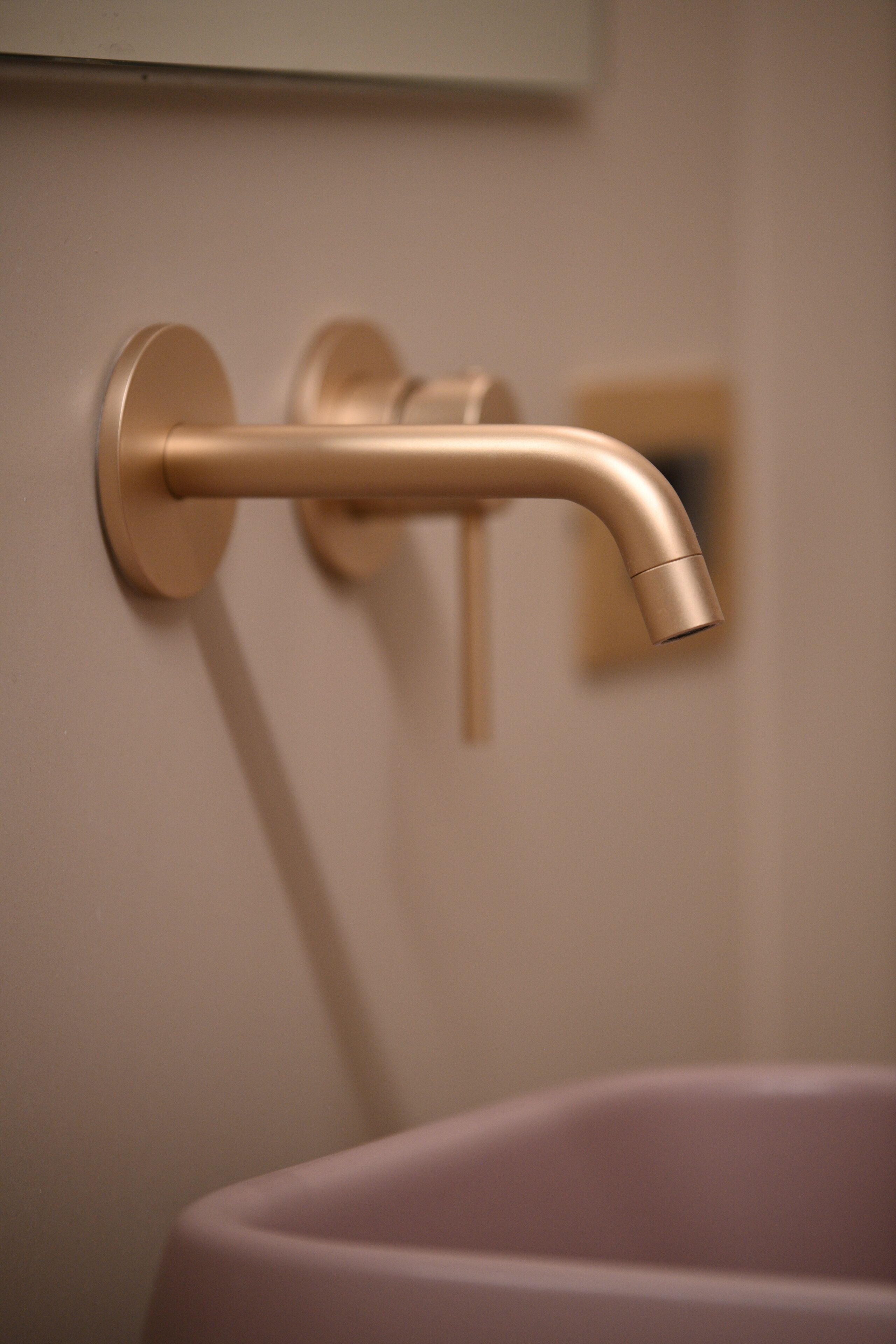A bathroom with a wall-mounted sink and a single faucet.