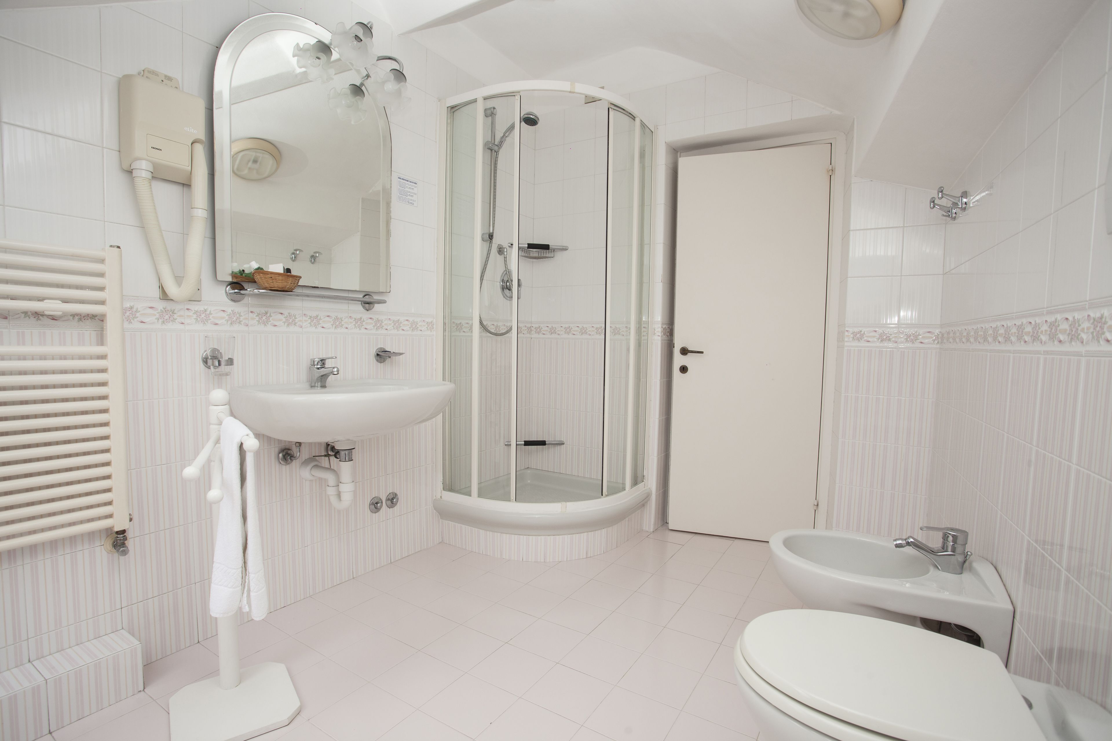 A modern bathroom with a shower, sink, toilet, and a towel rack.