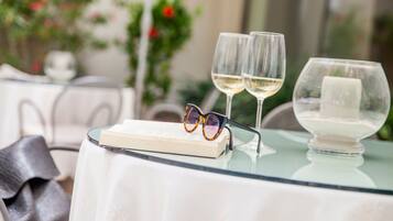 Ein Tisch mit zwei Weingläsern, einem Buch und einem Brillenpaar darauf.