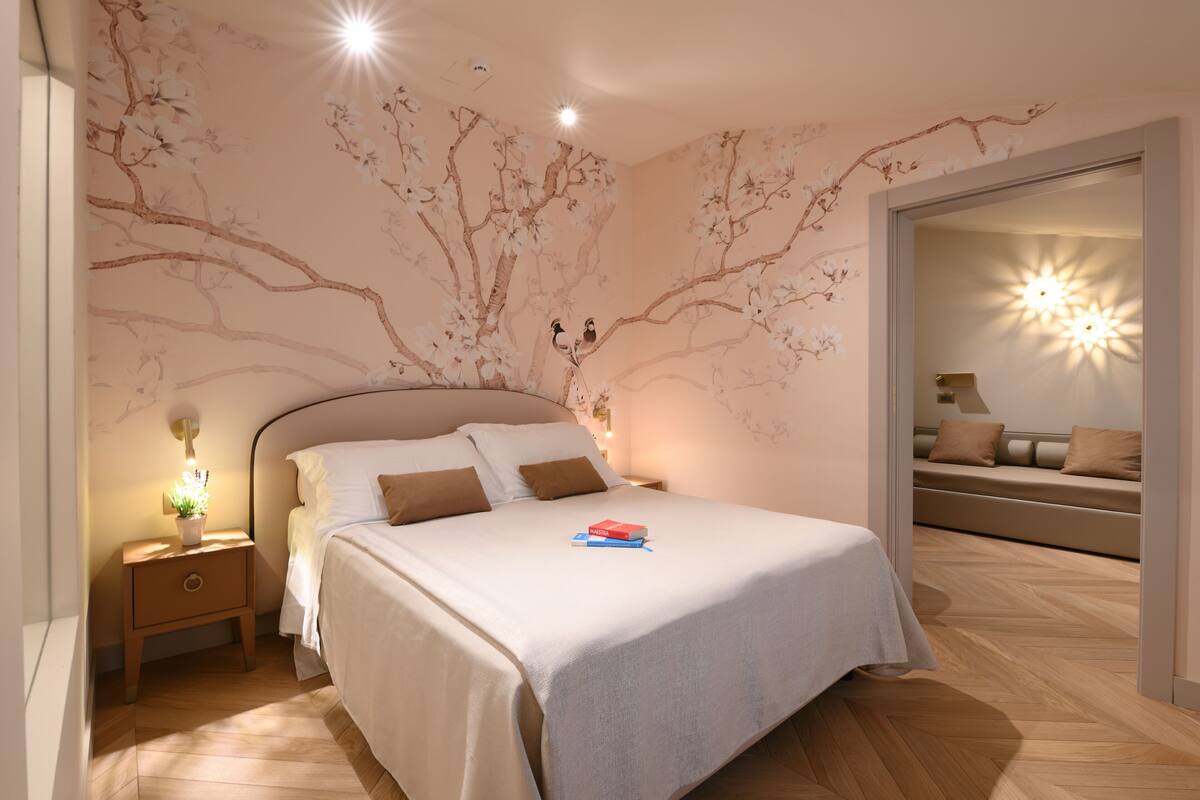 A bedroom with a bed, nightstand, and wall art.