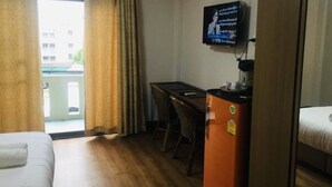 A hotel room with a bed, a desk, a television, and a view of the outside. - Home at Samlan Soi 1 (Chiang Mai)