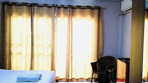 A hotel room with a bed, a chair, and a desk. - Home at Samlan Soi 1 (Chiang Mai)