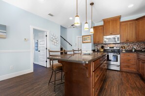 Enjoy cooking in this well-equipped kitchen with a central island, oven, and stainless steel range.