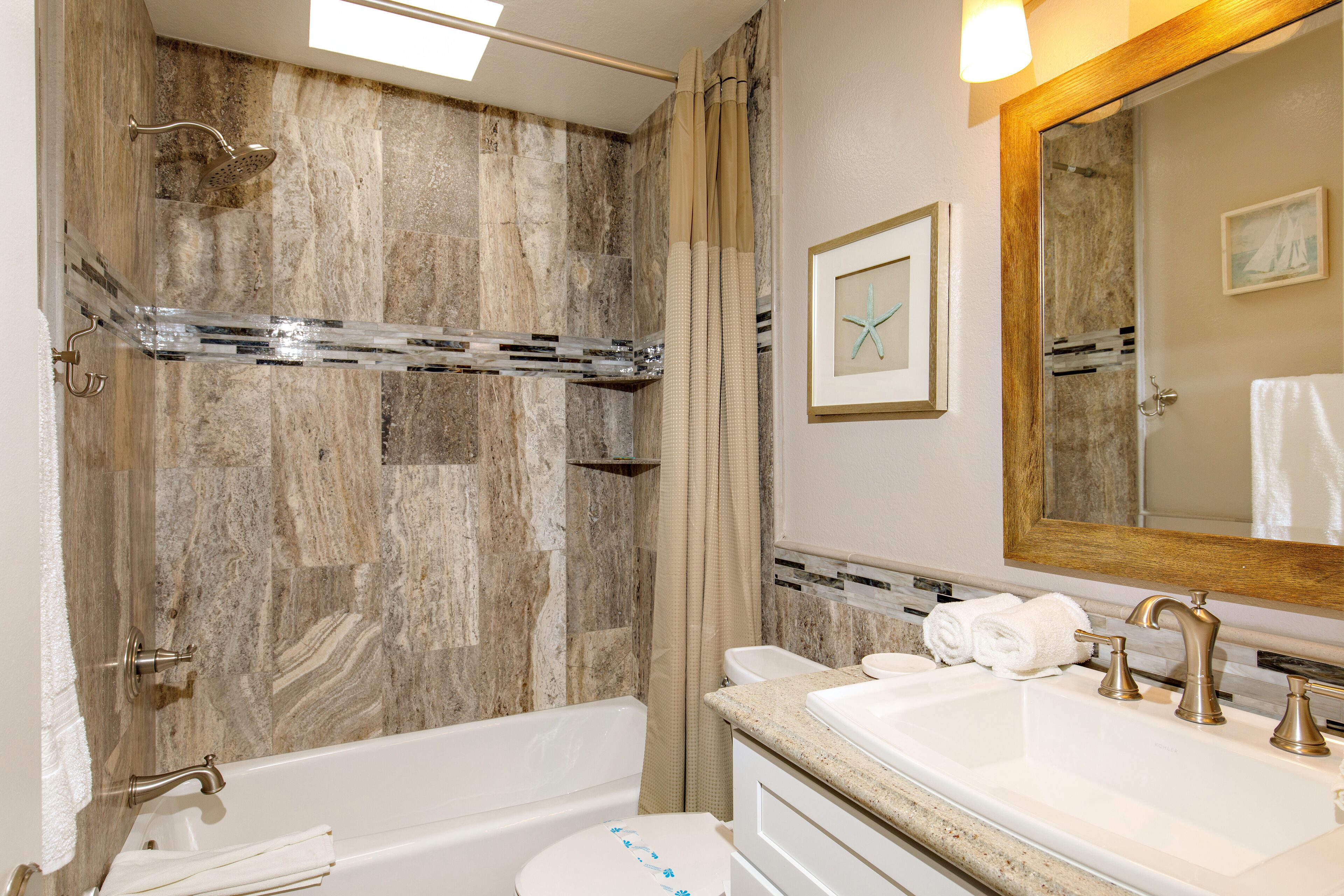 A bathroom with a bathtub, shower, and sink.