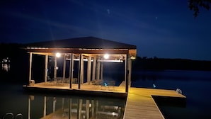 A docked house with a covered patio area, a pool, and a wooden deck. - Watts Bar Lake House (Spring City)
