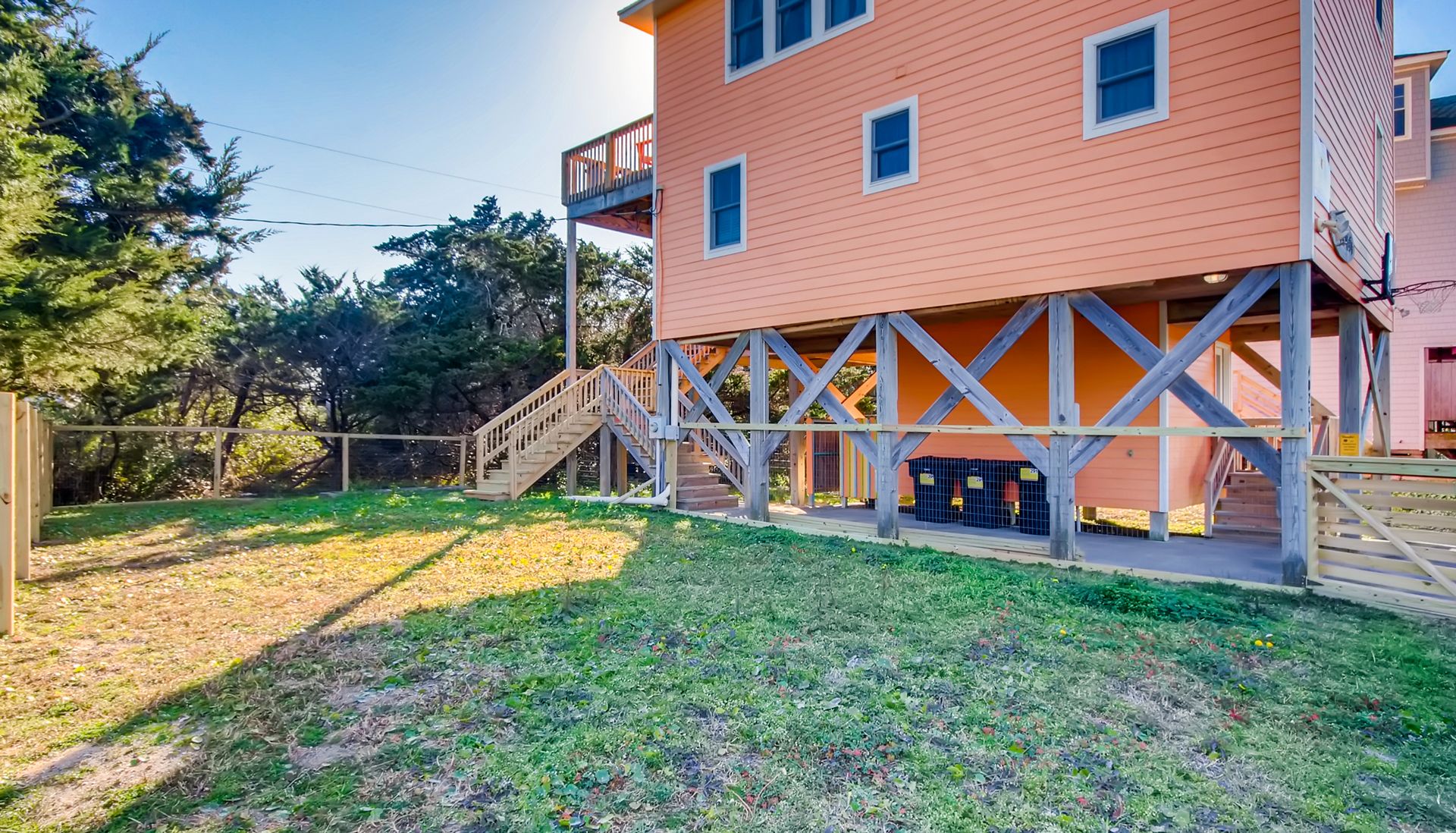 A fenced yard with a wooden structure and a building in the background.