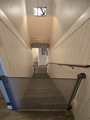 A wooden staircase with a sign reading "Beach" above it.