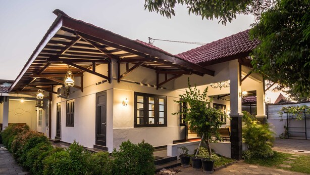 A house with a covered porch, potted plants, and a well-maintained garden. - Ndalem Sarengat (Yogyakarta)