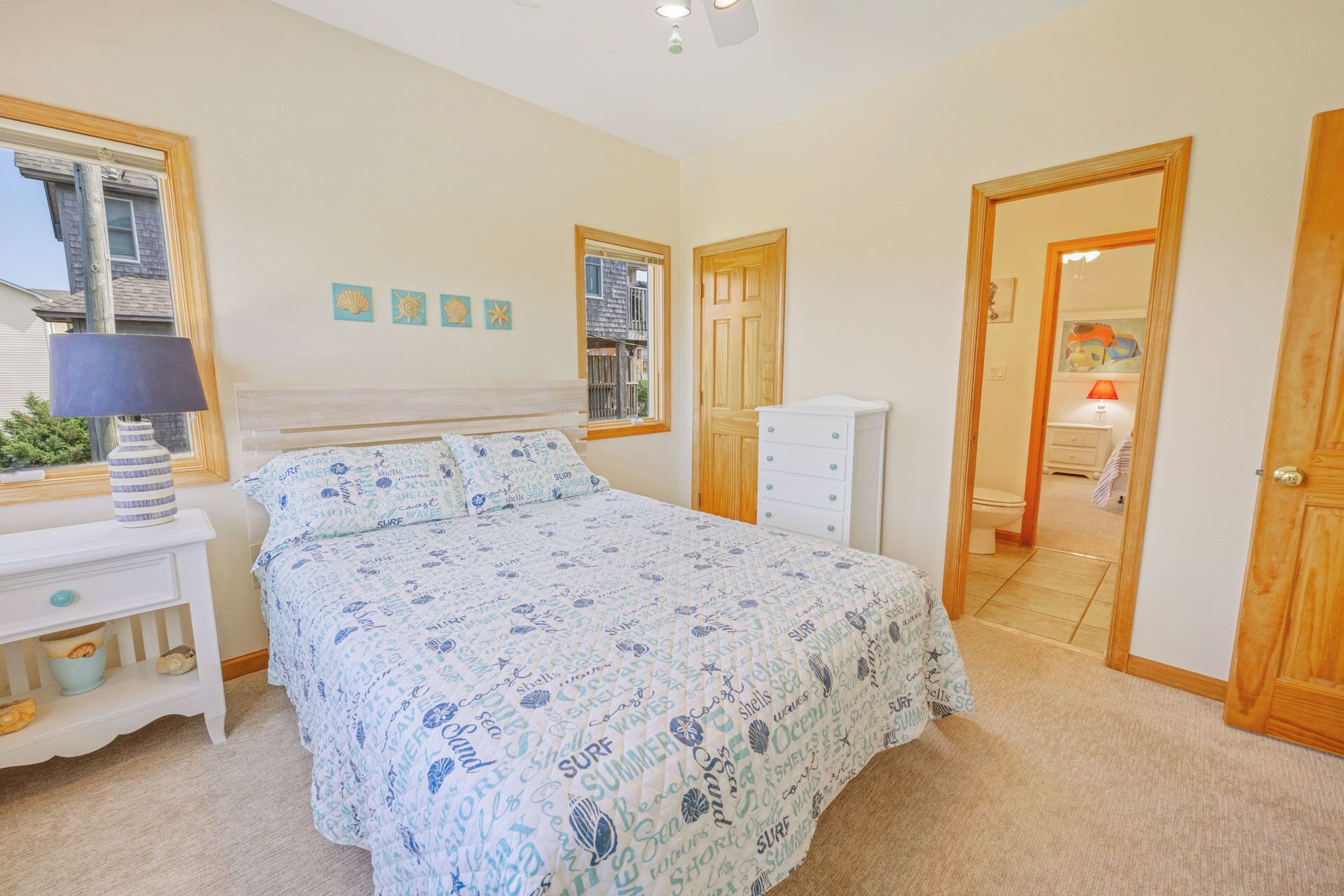 A bedroom with a bed, a dresser, a nightstand, and a window.