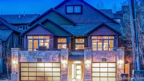 A two-story house with a stone facade, two garage doors, and a small balcony. - Luxury in Central Location. Shuttle outside door! Pool Table, Hot Tub, Ultra Lux (Park City)
