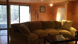 Una sala acogedora con un sofá modular, una mesa de centro y techo de madera.