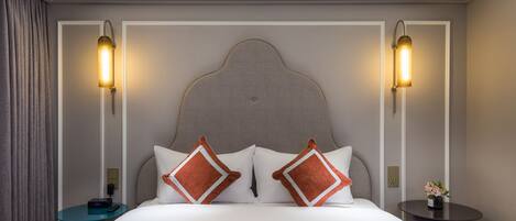 A hotel room with a large bed, two bedside tables, and a nightstand.