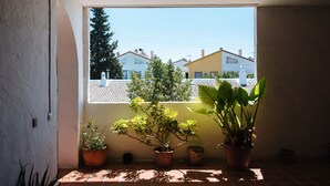 A balcony with potted plants and a view of houses in the background.