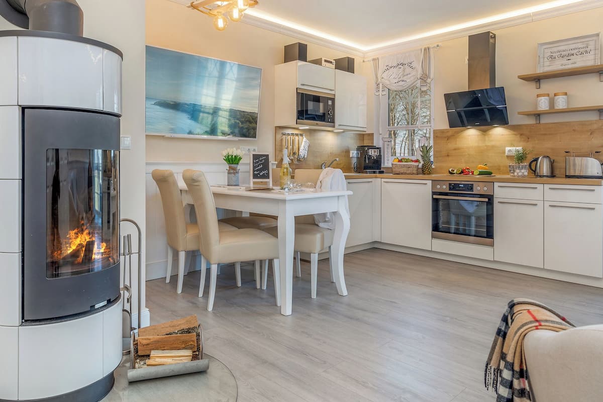 A modern kitchen with a built-in stove, dining area, and a large window.