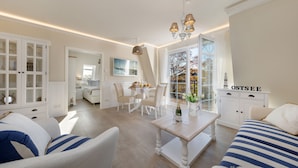 Un salón amplio con un gran ventanal, una zona de comedor y una acogedora zona de estar.