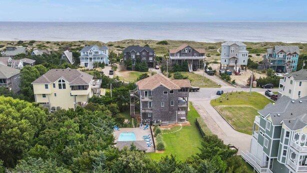 Un quartier résidentiel situé sur la côte, avec des maisons, une piscine et une vue sur l’océan.