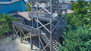 A multi-level wooden structure with a sign indicating 'SURF SOUND 77'. - Oceanview Dog Friendly Home in Avon w/ Grill, Games. Only 3 Lots From Beach! (Avon)