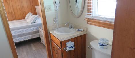 Une petite salle de bain avec un meuble-lavabo en bois, un évier, des toilettes et un miroir.