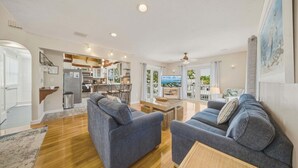 A spacious living room with two sofas, a coffee table, and a TV. - P46 - Beautiful updated home on the Gulf side with pool and dock! (Marathon)