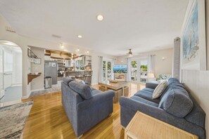 A spacious living room with two sofas, a coffee table, and a TV. - P46 - Beautiful updated home on the Gulf side with pool and dock! (Marathon)