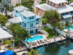 A multi-story house with a swimming pool, a dock, and a boat. - P46 - Beautiful updated home on the Gulf side with pool and dock! (Marathon)