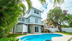 A two-story house with a pool, surrounded by lush greenery and a white fence. - P46 - Beautiful updated home on the Gulf side with pool and dock! (Marathon)