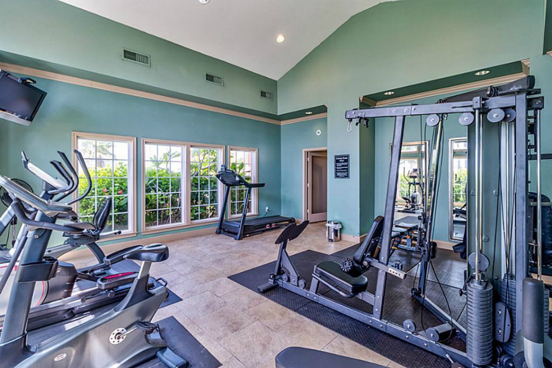 Ein Fitnessstudio mit Laufbändern, Crosstrainern und Gewichten.
