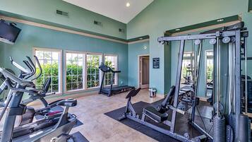 Ein Fitnessstudio mit Laufbändern, Crosstrainern und Gewichten.