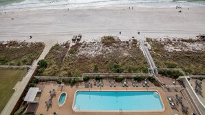 An aerial view of a beach resort with a swimming pool, beach chairs, and a lifeguard tower. - OPEN 9/19-9/21 OR 9/26-10/1 GULF VIEW 12th floor Condo on the beach (Panama City Beach)