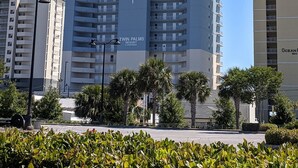 A high-rise hotel with multiple balconies, a prominent logo, and a clear sky. - OPEN 9/19-9/21 OR 9/26-10/1 GULF VIEW 12th floor Condo on the beach (Panama City Beach)