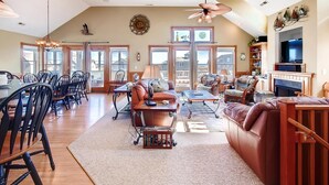 A spacious living room with a dining area, large windows, and a fireplace. - Semi-Oceanfront Home w/ Pool, Hot Tub, Elevator, Cabana w/ Tiki Bar, Game Room (Salvo)