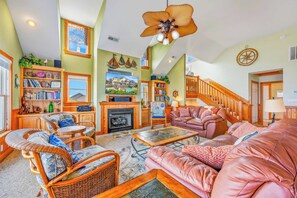 A spacious living room with a fireplace, comfortable seating, and a large television. - Semi-Oceanfront Home w/ Pool, Hot Tub, Elevator, Cabana w/ Tiki Bar, Game Room (Salvo)
