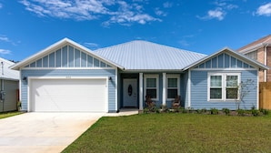 A single-story house with a garage, a front porch, and a well-maintained lawn. - Walk just 2 blocks to the beach! (PANAMA CITY BEACH)