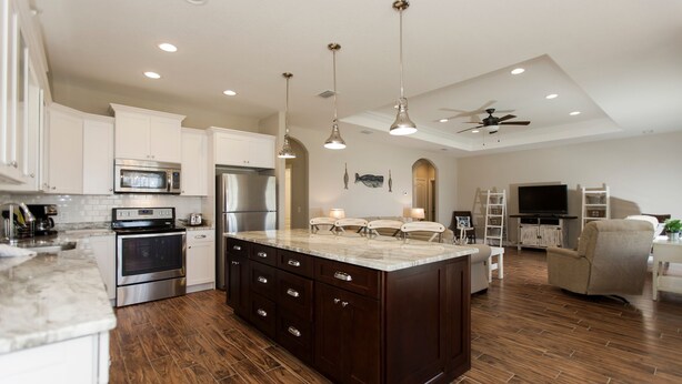 A spacious kitchen with a large island, stainless steel appliances, and pendant lighting. - Walk just 2 blocks to the beach! (PANAMA CITY BEACH)