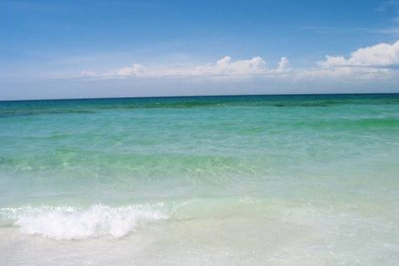 A beach with clear turquoise water and white sand.