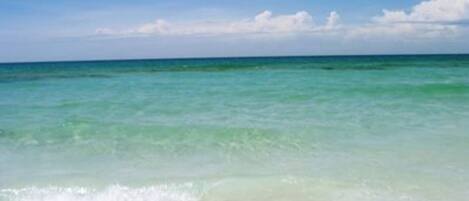 A beach with clear turquoise water and white sand.
