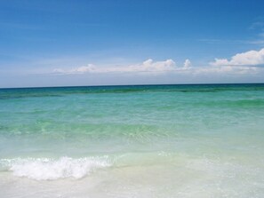 Een strand met helder turquoise water en een zandstrand.