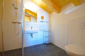 Une salle de bain avec une douche, un lavabo et des toilettes.