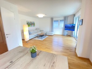 A modern living room with a sofa, coffee table, and a TV.