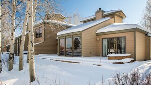 Una casa moderna con ampie finestre e un tetto imbiancato dalla neve.
