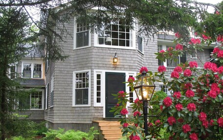 A two-story house with a grey exterior, white trim, and a black front door.