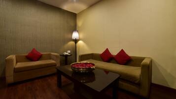 A room with two sofas, a coffee table, and a lamp.