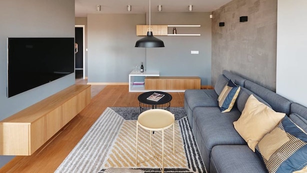 A modern living room with a flat-screen TV, a sofa, a coffee table, and a pendant light. - Funky Flat (Sofia)