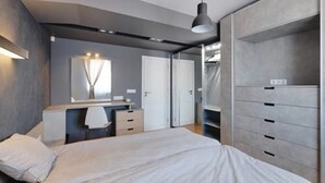 A modern bedroom with a bed, bedside table, wardrobe, and a mirror. - Funky Flat (Sofia)